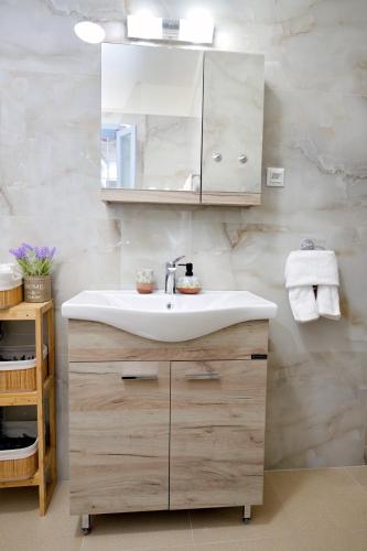 a bathroom with a sink and a mirror at Aroura Homes Spetses 3BR 2BA in Spetses