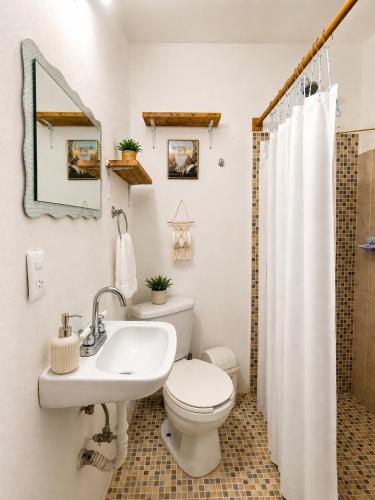 a bathroom with a white toilet and a sink at Cocoa by Casa Momo Apartamento Acogedor y Céntrico in Bacalar