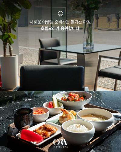 un vassoio di cibo su un tavolo con ciotole di cibo di Hotel ORA Incheon a Incheon