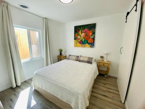 a bedroom with a bed and a painting on the wall at Private Pet-Friendly Casita in Phoenix