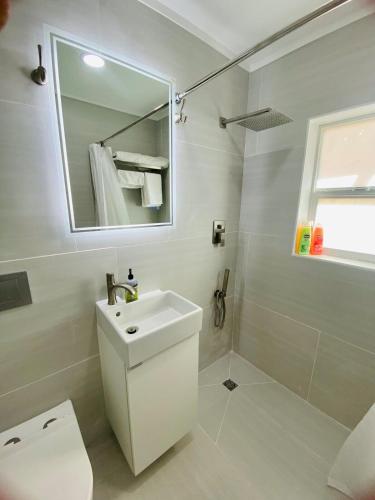 a white bathroom with a sink and a mirror at Private Pet-Friendly Casita in Phoenix
