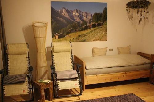 a bedroom with a bed and a painting on the wall at Aussermairhof in Campo Tures