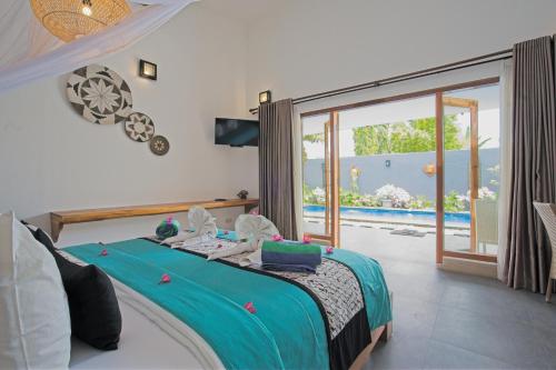 a bedroom with a bed with a view of a pool at KyGunAya Villa in Gili Islands