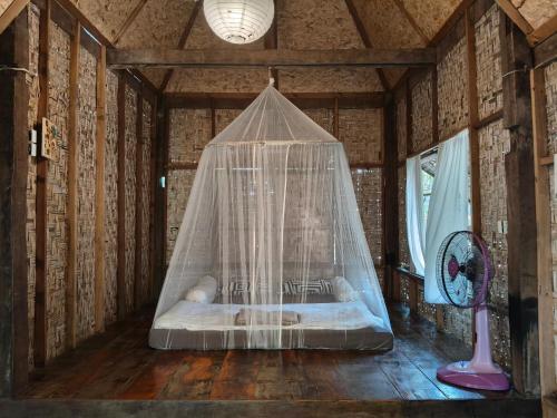 a bed in a room with a net at pannaburee resort in Ban Khanong Phra Klang (1)