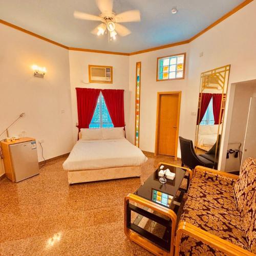 a large bedroom with a bed and a couch at Qurum Heights Hotel in Muscat