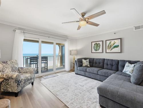 a living room with a couch and a ceiling fan at Kingfisher Oceanfront Condo w Pool & Elevator in North Topsail Beach