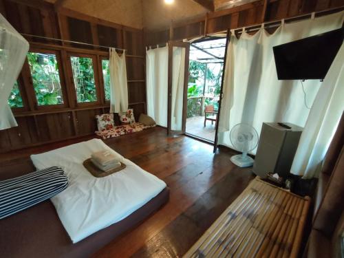 a bedroom with a bed and a television and a living room at pannaburee resort in Ban Khanong Phra Klang (1)