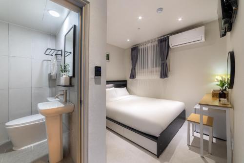 a small bathroom with a bed and a toilet at BigBoxStay Myeongdong in Seoul