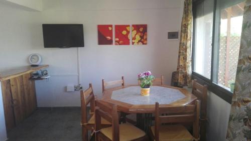 un tavolo da pranzo con un vaso di fiori sopra di Casas Altas VGB a Villa General Belgrano