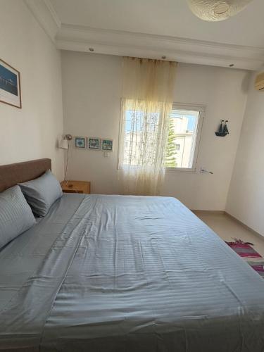 a large bed in a bedroom with a window at Lac 2 Tunisi in El Aouina Station