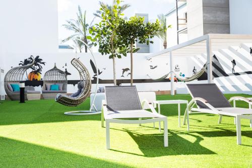 a green lawn chair sitting in the middle of a lawn at Corralejo Surfing Colors Hotel&Apartments in Corralejo