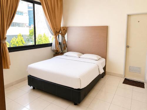 a bed in a room with a large window at Marina Jampea Hotel in Makassar