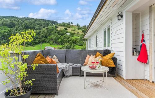 a patio with a couch and a table on a porch at Awesome Apartment In Strandebarm in Strandebarm