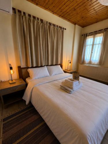 a bedroom with a large white bed with a window at Apokas Country House in Zoopiyi