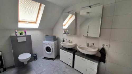 a bathroom with two sinks and a washing machine at Wohnung Maric bis zu 11 Personen in Neunburg vorm Wald