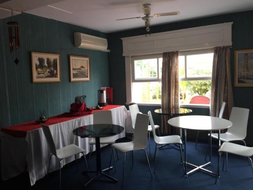 a dining room with tables and chairs and a window at Alpes Hotel in Punta del Este