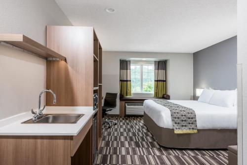 a hotel room with a bed and a sink at Microtel Inn & Suites by Wyndham New Martinsville in New Martinsville