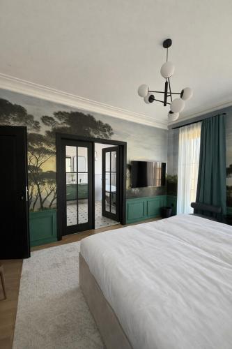 a bedroom with a large bed and a painting on the wall at Berek Kúria in Sonkád
