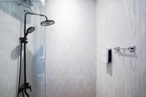 a shower with a glass door in a bathroom at The Lavana Infinity Jogja Villa in Salakan