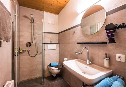a bathroom with a sink and a shower and a toilet at App. Fam. Dr. Goldberger in Söll