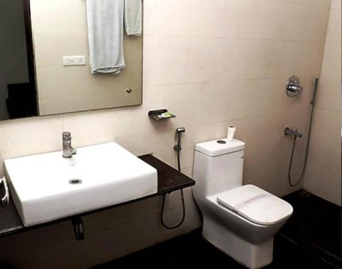 a bathroom with a sink and a toilet and a mirror at ToBo Retreat Agra Taj Mahal in Agra