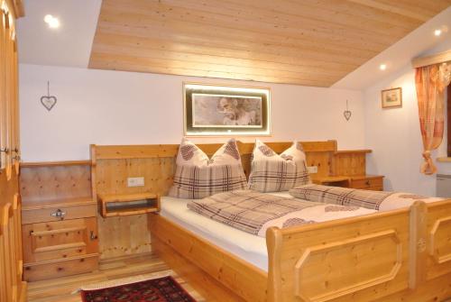 a bedroom with a wooden bed with a picture on the wall at Haus Kraft in Sankt Martin am Tennengebirge