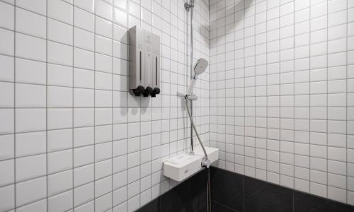 a bathroom with a white tiled wall with a toothbrush at Cheongju Hotel Dictionary in Cheongju