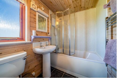 a bathroom with a sink and a tub and a toilet at Ewe Lodge in Ashbourne