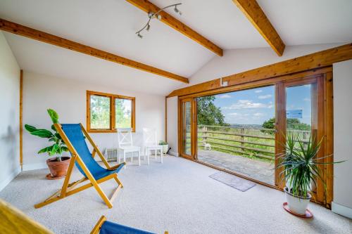 a room with a rocking chair and a large window at Ewe Lodge in Ashbourne