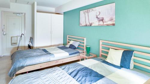 a bedroom with two beds and a painting of a deer at 9Stay川崎 in Kawasaki