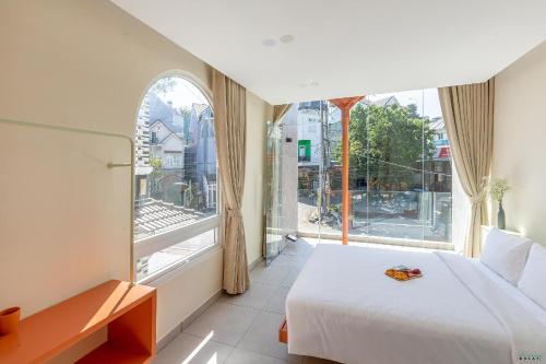 a bedroom with a bed and a large window at Bazan Dalat Hotel in Da Lat
