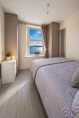 a bedroom with a large bed and a window at Unit 5 Stunning Oceanview Apartment in Cobh
