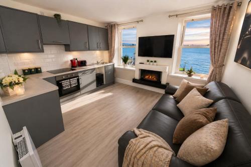 a living room with a couch and a kitchen at Unit 5 Stunning Oceanview Apartment in Cobh