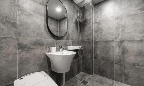 a bathroom with a toilet and a sink and a mirror at Pohang Hotel La Terrace in Pohang