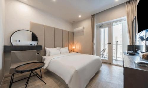 a bedroom with a large white bed and a mirror at Pohang Hotel La Terrace in Pohang