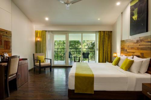 a hotel room with a bed and a balcony at Wayanad Wild - A CGH Earth Experience in Vythiri