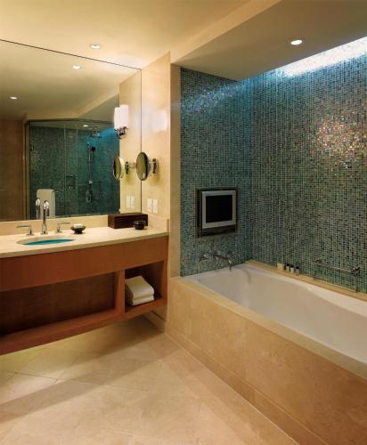 a bathroom with a tub and a sink and a mirror at Grand Hyatt Incheon in Incheon