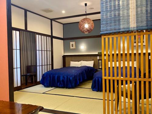 a bedroom with a bed with blue sheets in it at Good Stay Mizuho in Usa