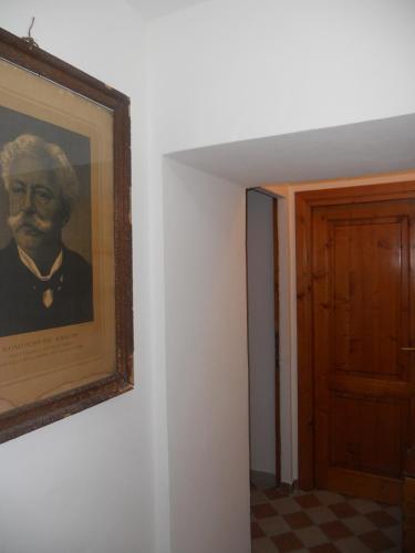 a painting of a man on a wall next to a door at Il Pozzo Della Citerna in Castelnuovo Berardenga