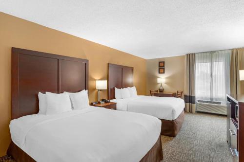 a hotel room with two beds and a television at Comfort Inn North Conroe in Conroe
