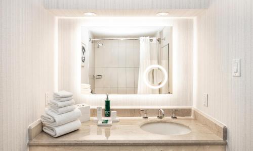 a white bathroom with a sink and a mirror at Hilton Washington DC Capitol Hill in Washington, D.C.