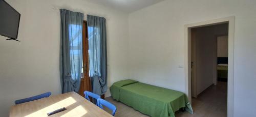 a room with a table and a bed and a window at Villa Cedro in Capoliveri