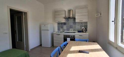a kitchen with a table and chairs and a refrigerator at Villa Cedro in Capoliveri