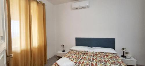 a bedroom with a bed with a blue headboard at Villa Oleandro in Capoliveri