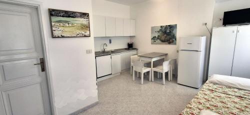 a kitchen with a white refrigerator and a table at Villa Oleandro in Capoliveri