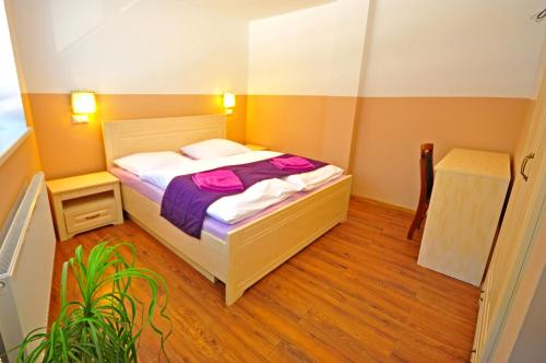 a small bedroom with a bed and a plant at Apartment Bartek Ski Rental in Demanovska Dolina