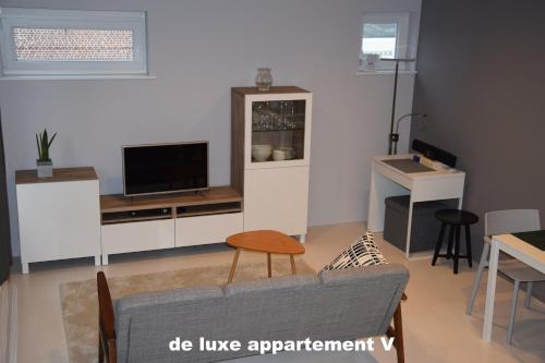 a living room with a couch and a tv at B2B-flats AALST in Aalst