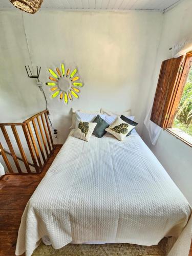a bedroom with a white bed with pillows on it at Viva o Capao - Casas in Palmeiras