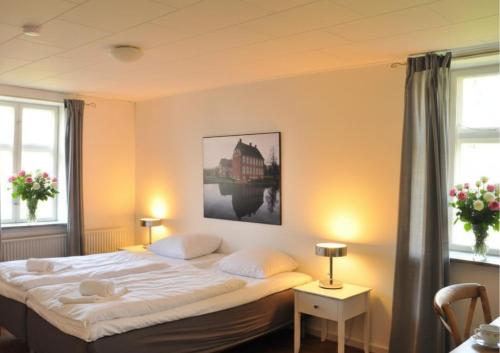 a bedroom with a large white bed with two windows at Gram Slot in Gram
