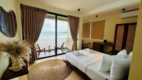 a bedroom with a bed with a view of the ocean at Meli Beach in Galle
